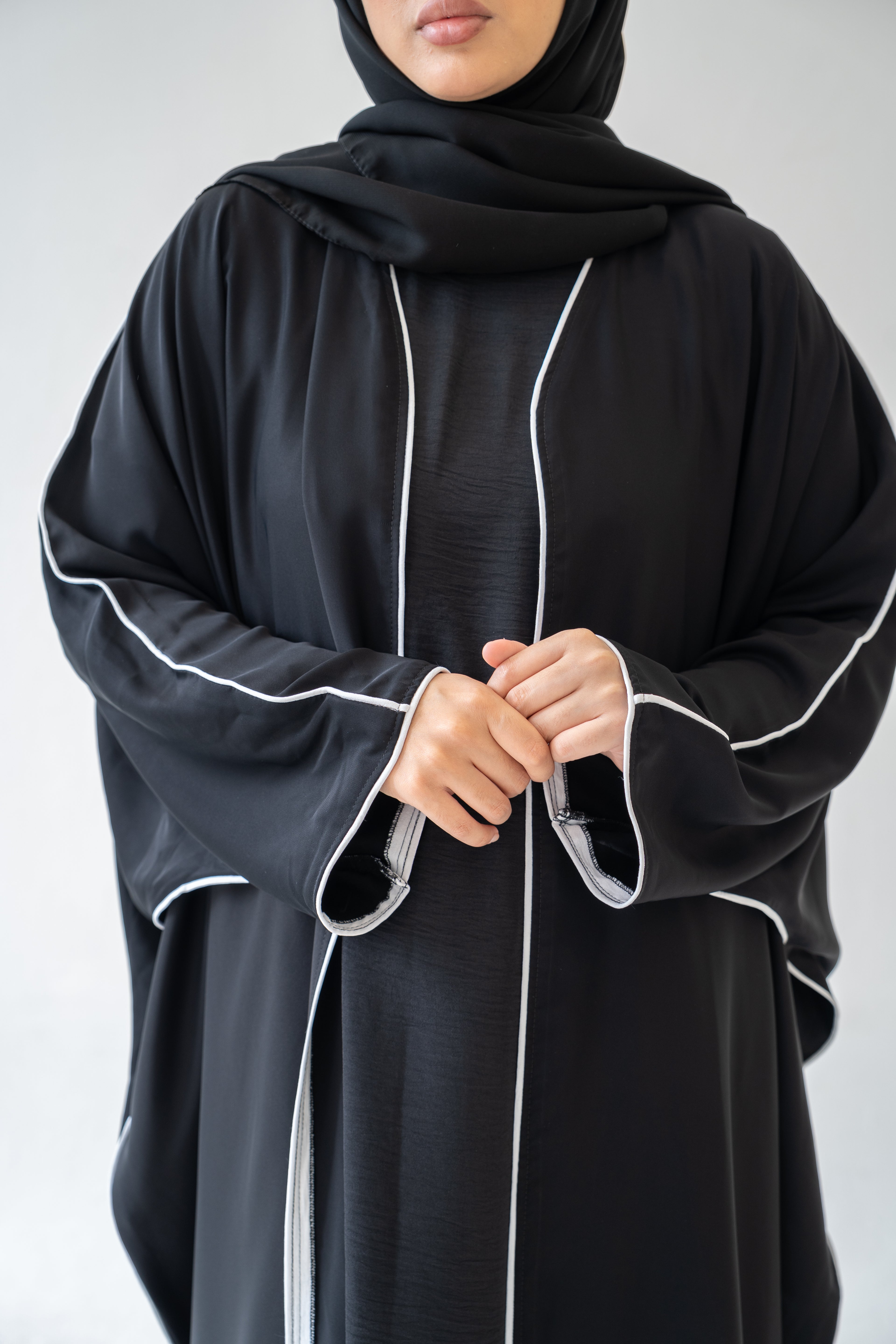 Close‑up of piping on Black Abaya with White Piping
